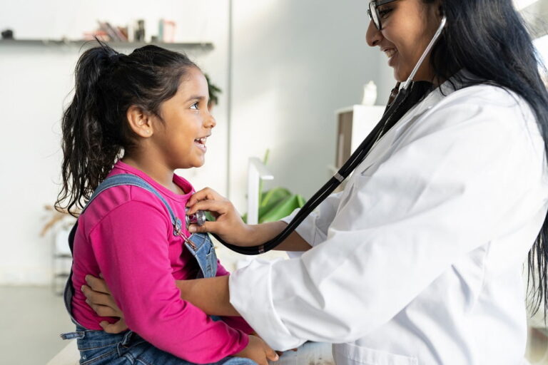 Jovem estudante de curso de formação de médico pediatra atende menina em consultório
