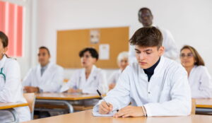 Jovem médico estrangeiro fazendo a prova do Revalida em uma sala de aula