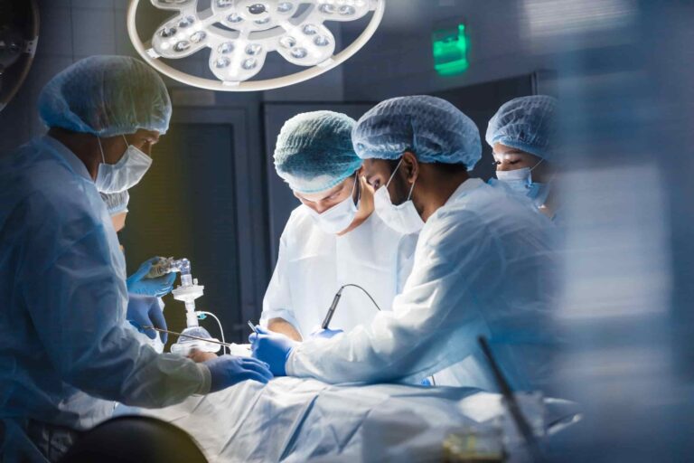 Médico na prática da pós-graduação durante cirurgia junto de equipe