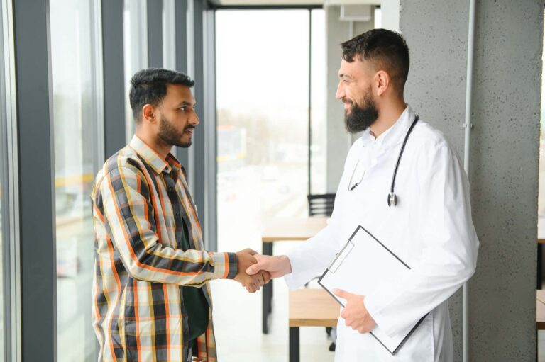 Médico estrangeiro cumprimentando paciente depois de aprender o português
