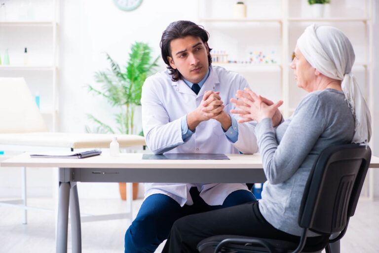 Jovem médico em especialização em cardio-oncologia atendendo paciente com câncer