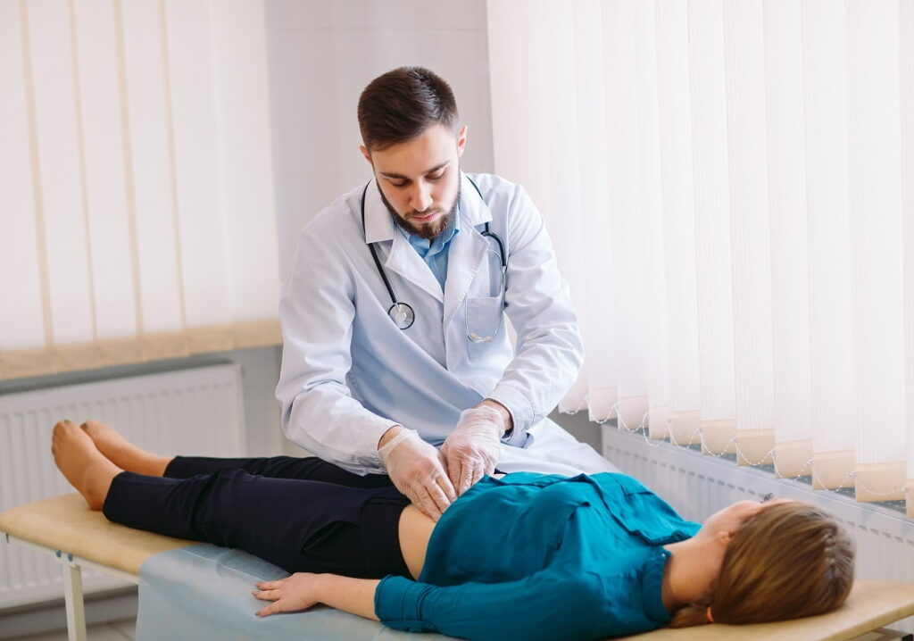 Jovem médico em especialização em gastroenterologia atendendo paciente em consultório