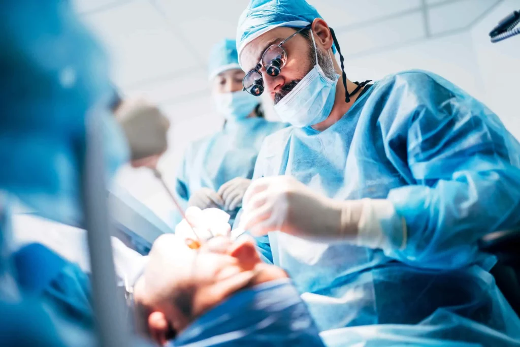 Médico executando cirurgia bucomaxilofacial em paciente