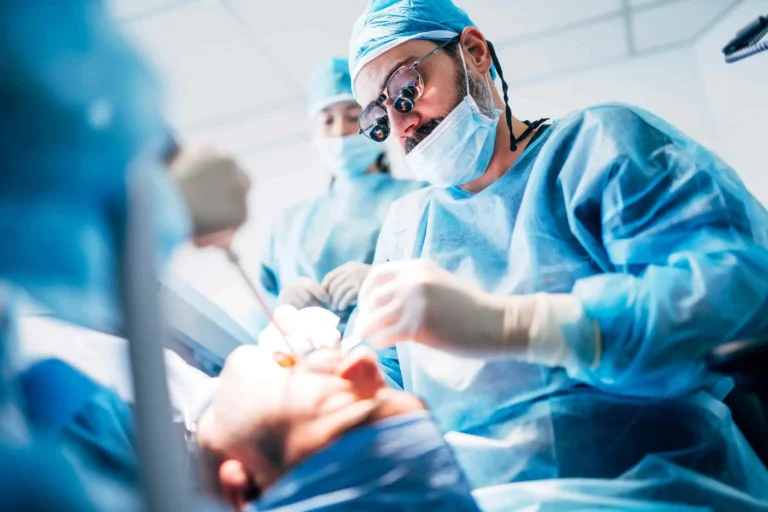 Médico executando cirurgia bucomaxilofacial em paciente
